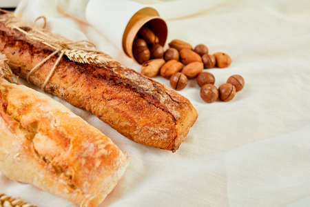 Top view of two baguettebread and nuts on a textile surface.の写真素材