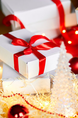 DIY Christmas present wrapping Christmas gift white box with a red ribbon, festive decoration on the table.の写真素材
