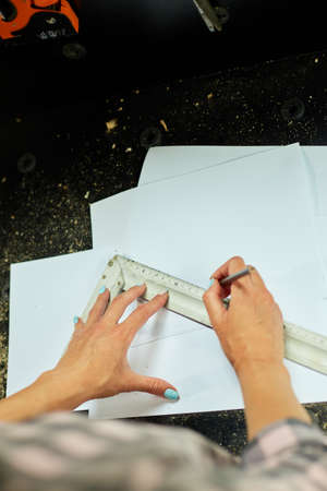 Female interior designer working on drawings, woman architect draws with ruler plan of new apartment...