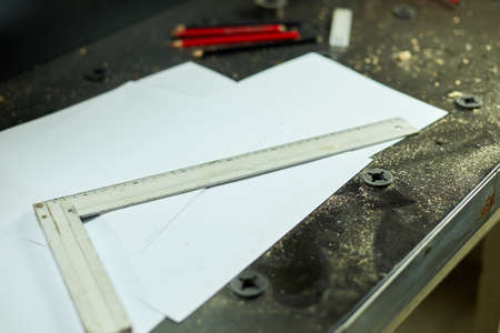 Table with paper, pencil, ruler, architect draws  plan of new apartment design at workshop, design project blueprints for new construction projectの写真素材