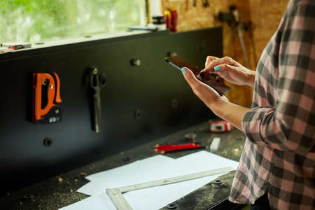 Female business owner using digital tablet in workshop, industrial woman engineer working with blueprints and tablet in the workshop.の写真素材