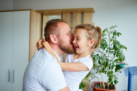 Father and daughter in white spending time at home, handsome man playing with his little cute girl, having fun relaxing spending time together, Happy Father's Day.の写真素材