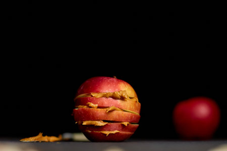 Red slices sandwich or burger of apple with peanut butter on dark background, healthy snack, nutrition and diet food.の写真素材