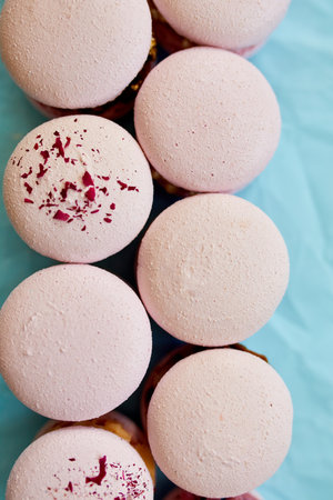 Assorted sweet french pink macarons on blue background pastry assortment, sweet indulgence.