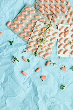 An artistic arrangement of medication with spring blossoms symbolizing health and renewal.