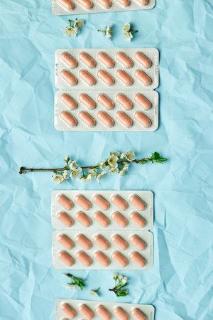 An artistic arrangement of medication with spring blossoms symbolizing health and renewal.