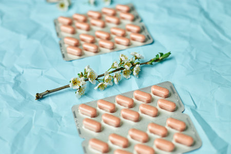 An artistic arrangement of medication with spring blossoms symbolizing health and renewal.