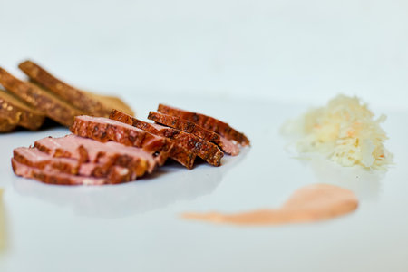 Sliced rye bread, corned beef, cheese, sauerkraut, and dressing are artfully displayed on a white surface, inviting assembly into a delicious Reuben sandwich ingredientsの写真素材