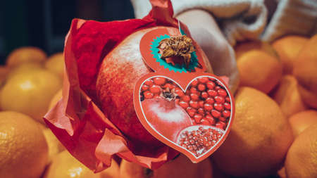 hands holding garnet fruit in hands in the shop or marketの写真素材
