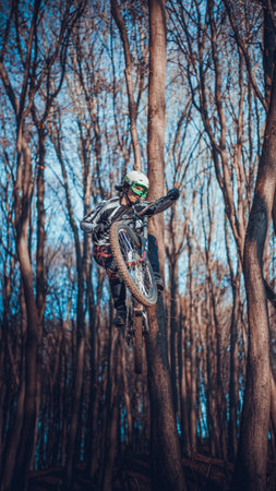 Riding on mtb bikes, downhill bikes in autumn forest on bike trails wish tricks and huge gaps and jumpsのeditorial素材