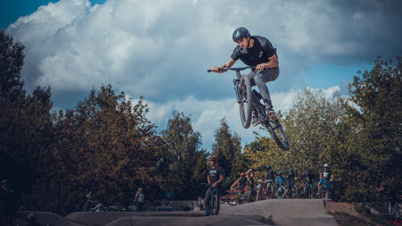 Summer riding on mtb bikes on pumptrack 4cross with tricks and big air jumps in outdoor bike parkのeditorial素材