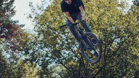 Summer riding on mtb bikes on pumptrack 4cross with tricks and big air jumps in outdoor bike parkのeditorial素材