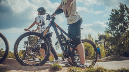 Summer riding on mtb bikes on pumptrack 4cross with tricks and big air jumps in outdoor bike parkのeditorial素材