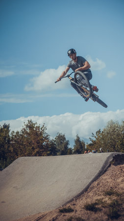 Summer riding on mtb bikes on pumptrack 4cross with tricks and big air jumps in outdoor bike park