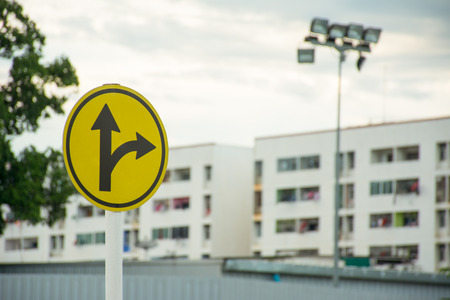 Sign turn right or go straight with blur city backgroundの写真素材