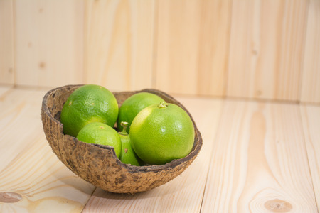 Lemons in coconut shell on wooden tableの写真素材