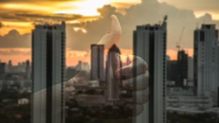 Abstract blur of business towers before sunset with thumb up.の写真素材