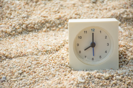 Clock on sand with hight sunlight.の写真素材
