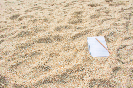 Blank note with pencil on the beachの写真素材