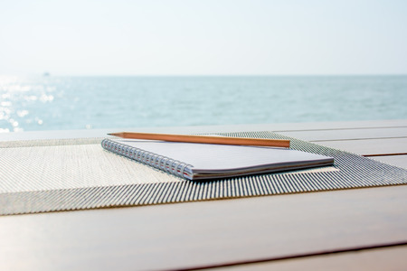Blank note with pencil on the beachの写真素材