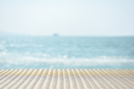 White woven bamboo table with beautiful sea in backgroundの写真素材