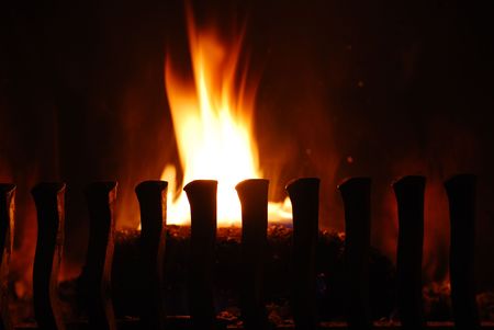 fireplace with burning wood and flames in the darkの写真素材