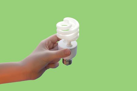 Hand holding energy saving CF light bulb onの写真素材