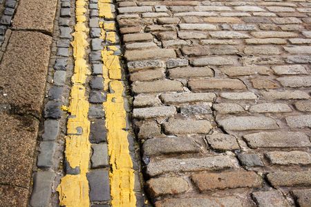 Modern (no parking) double yellow lines along ancient cobble stonesの写真素材