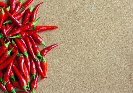 Ripe red chillies on cork boardの写真素材