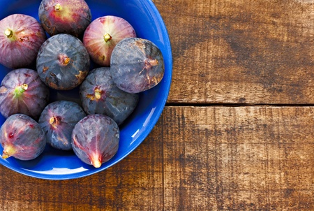 Bowl of ripe figs on rustic wooden tableの写真素材