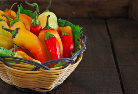 Basket of chillies on old wooden tableの写真素材