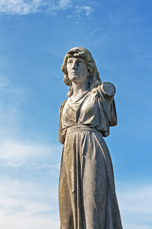 Female weathered statue in ancient graveyardの写真素材
