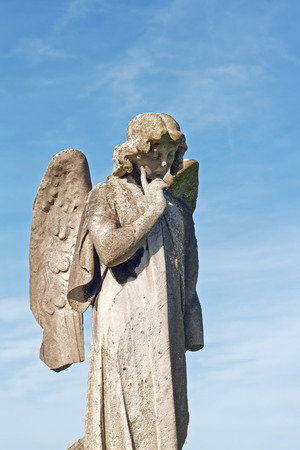Winged angel statue in ancient graveyardの写真素材