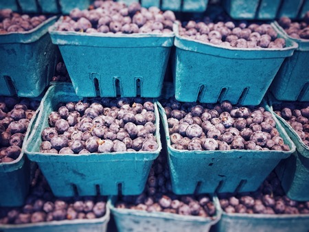 Stack of seasonal fresh local blueberries, for sale in a produce market, Canada.の写真素材