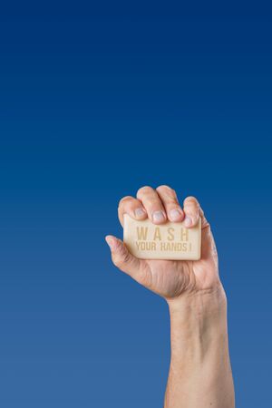 Caucasian male hand holding bar of soap with message Wash Your Handsの写真素材