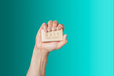 Caucasian male hand holding bar of soap with message Wash Your Handsの写真素材