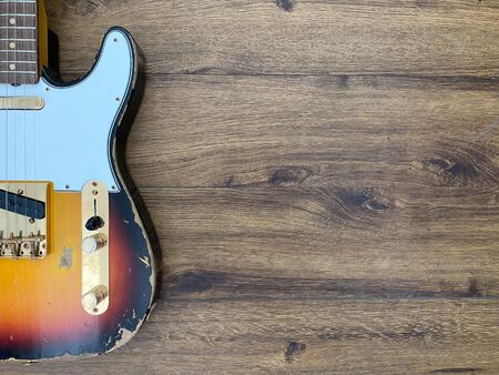 vintage guitar on a wooden background.