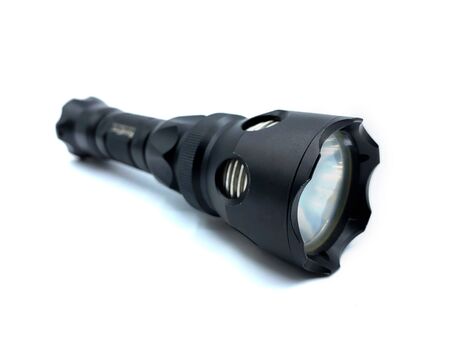 Close-up of a black modern flashlight, isolated on white backgroundの写真素材
