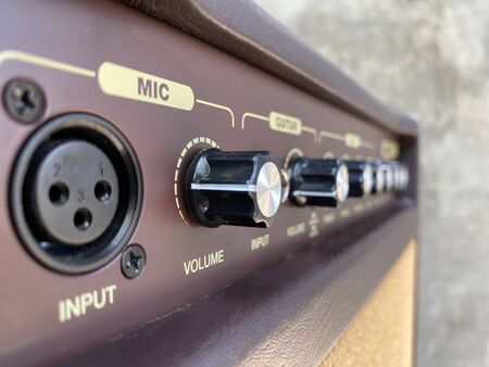 Close-up black knob, brown panel vintage acoustic combo amplifier.の写真素材