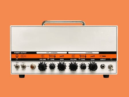 Isolated white iron modern drive medium electric guitar amplifier head on orange background with copy spaceの写真素材