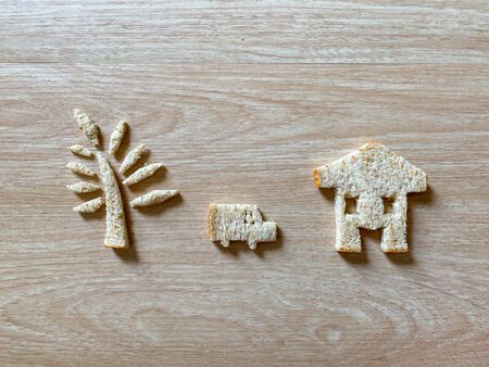 slice of bread cut into the marks of the wheat has a symbol that symbolizes the carriage. There is a delicious smell laid on the wood grain background, ideas and concepts comparing bread and business.の写真素材