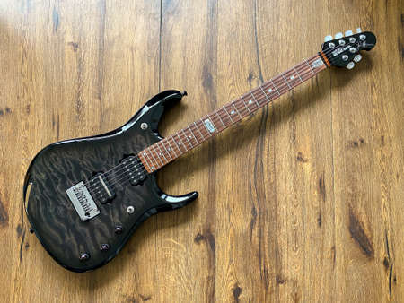 Bangkok, Thailand - June 10, 2020 : Music man BFR - Ball Family Reserve Black maple electric guitar signature of john petrucci guitarist of dream theater band on wooden background in music store.のeditorial素材