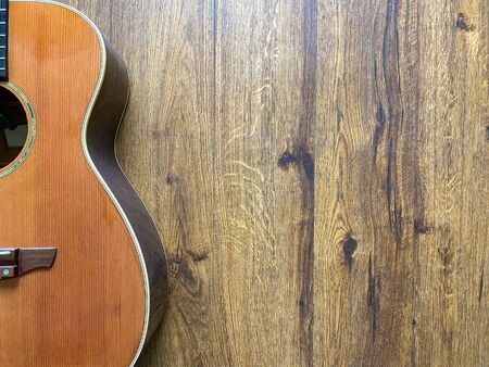 natural acoustic guitar made from a genuine spruce top Popular musician on veneer brown wood background with copy space on right for letter. business and music concept. Wallpaper or background.の写真素材