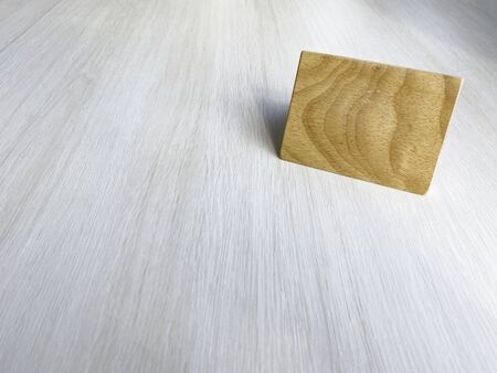 A sign made of brown alder wood is placed on a white wooden table in the upper right corner. In a cafe, a coffee shop with copy space. cafe business.の写真素材