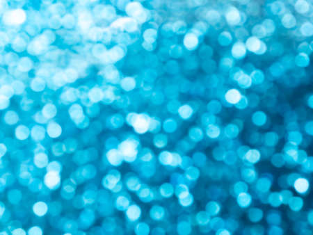 Abstract colorful blue and silver small bokeh Looks bright effect texture on black background. glitter vintage lights defocused elegant for Christmas or celebrate. Sparkling magical dust particles.の写真素材