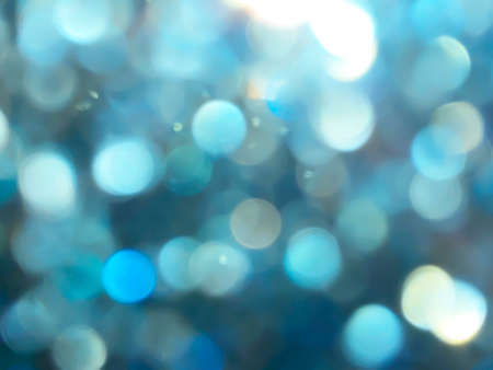 Abstract colorful Blue bokeh on glass in rainy day Look bright effect texture on black background. glitter lights defocused elegant for cosmetics or celebrate. Sparkling magical dust particles.の写真素材