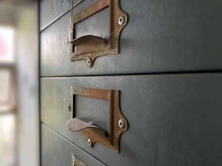 Close-up of the old gray handle cabinet drawers that are closer That has been in the office for a long time until old Can be used to compose in vintage classics.の写真素材