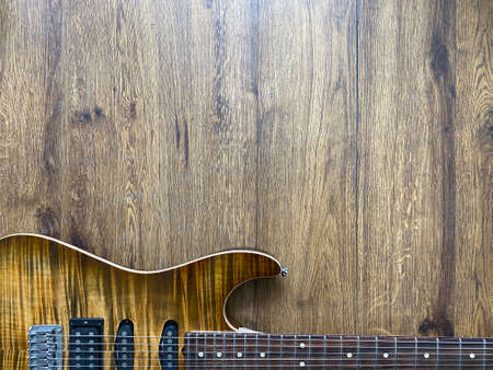 honey burst electric guitar made from a genuine alder wood Popular musician on veneer brown wood background with copy space on the bottom for letter. business and music concept. Wallpaper or background.の写真素材