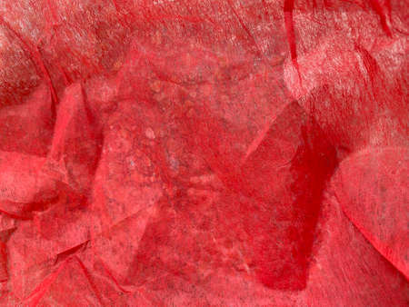 Close-up of natural red fabric or cloth in light red color. Fabric texture of natural cotton or linen textile material. Red canvas background for banner, cover book with copy spaceの写真素材