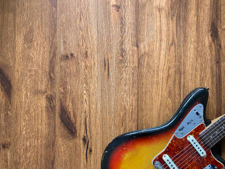 Vintage Sunburst Relic electric guitar made from a genuine Alder wood on veneer wood background with copy space for letter. business and music concept. Wallpaper or background.の写真素材